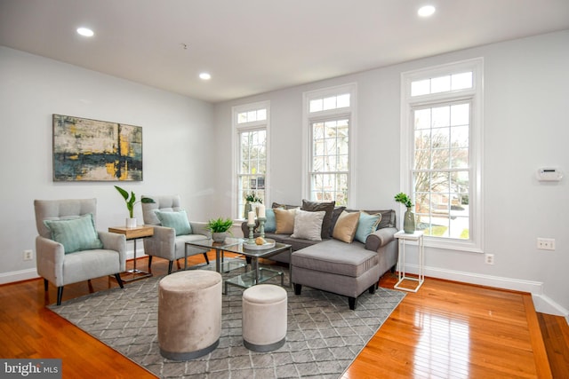 living area with recessed lighting, a healthy amount of sunlight, and hardwood / wood-style floors