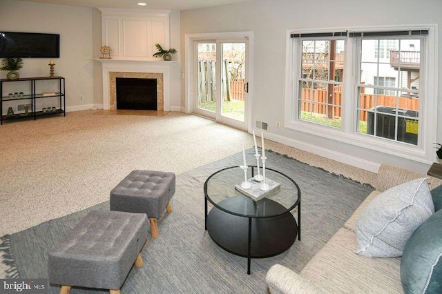 carpeted living area with recessed lighting, baseboards, a large fireplace, and visible vents