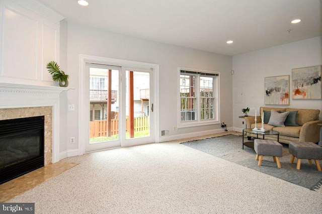 living room featuring a high end fireplace, carpet flooring, recessed lighting, and baseboards