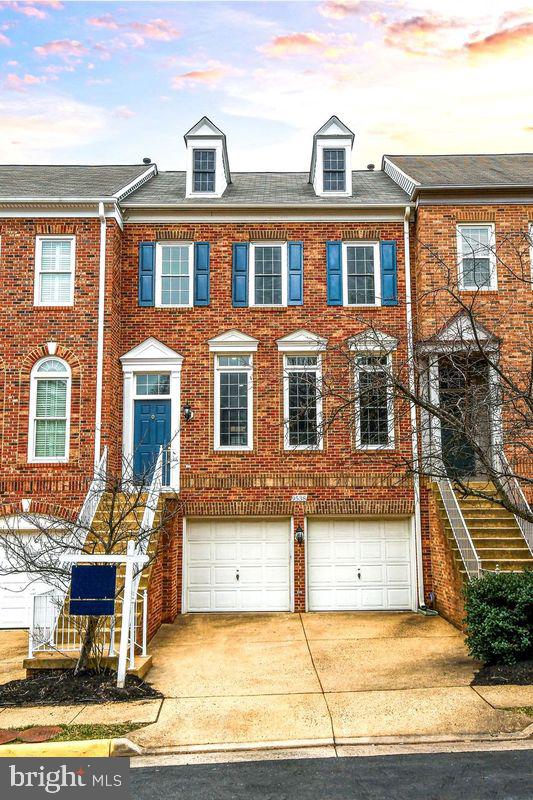 townhome / multi-family property featuring brick siding, an attached garage, concrete driveway, and roof with shingles