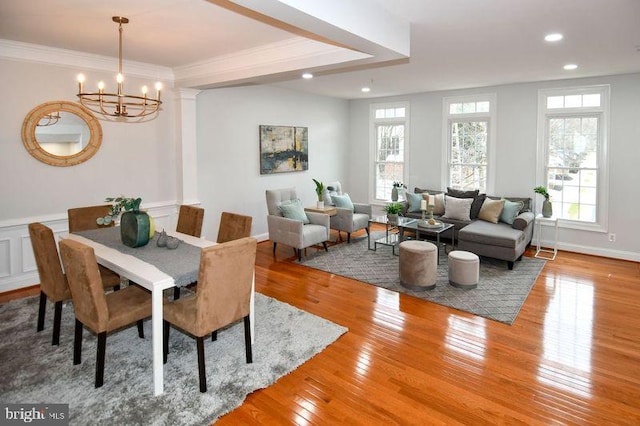 dining room with crown molding, baseboards, hardwood / wood-style floors, recessed lighting, and an inviting chandelier