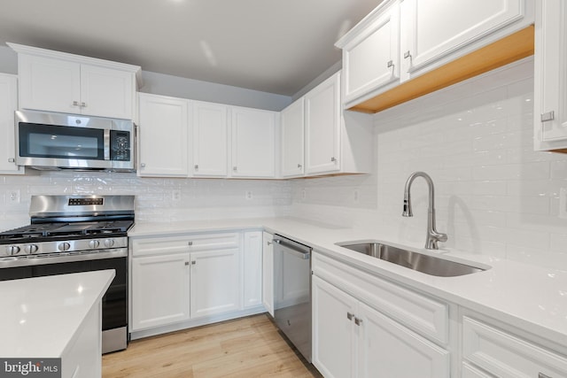 kitchen featuring white cabinetry, stainless steel appliances, light hardwood / wood-style floors, and sink