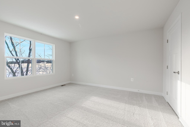 unfurnished room featuring light colored carpet