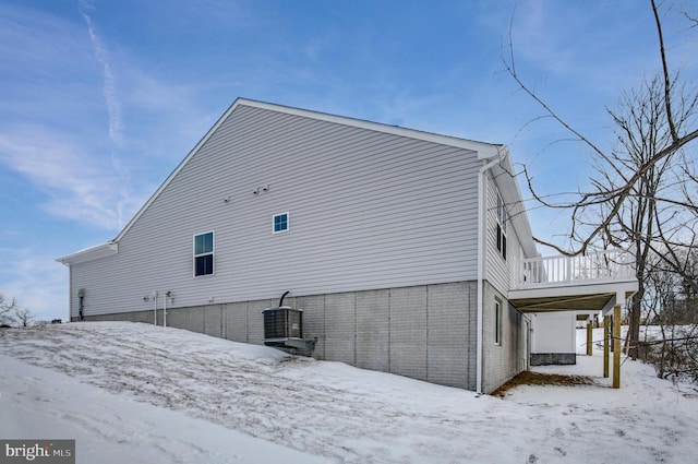 snow covered property with central AC unit