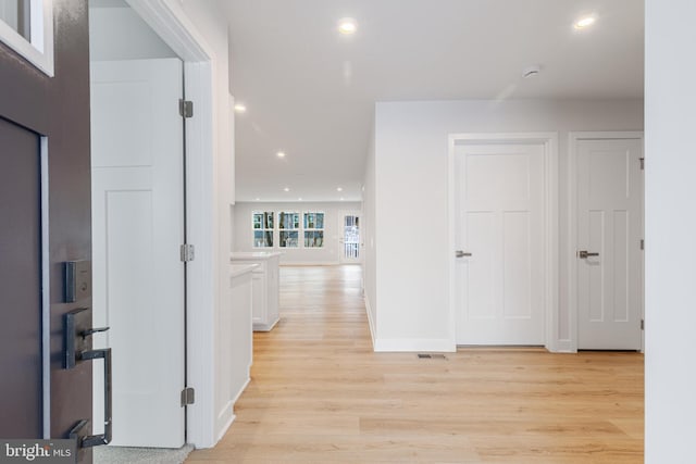 hallway with light hardwood / wood-style floors