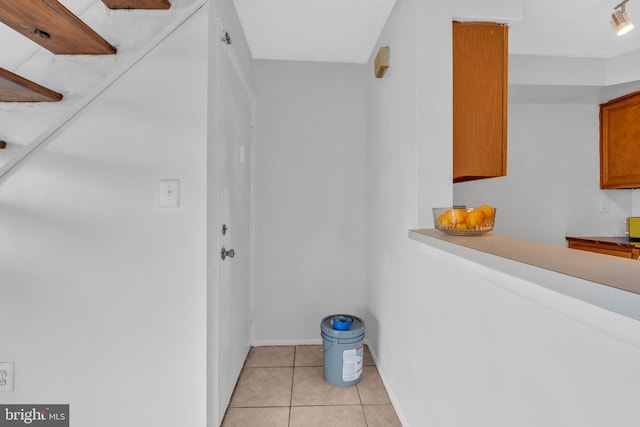 interior space with baseboards and light tile patterned floors