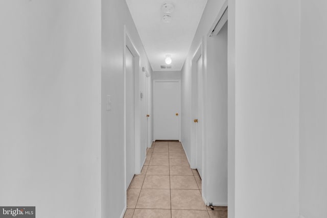 hall featuring visible vents and light tile patterned floors