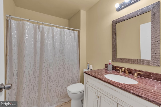 bathroom with tile patterned flooring, vanity, and toilet