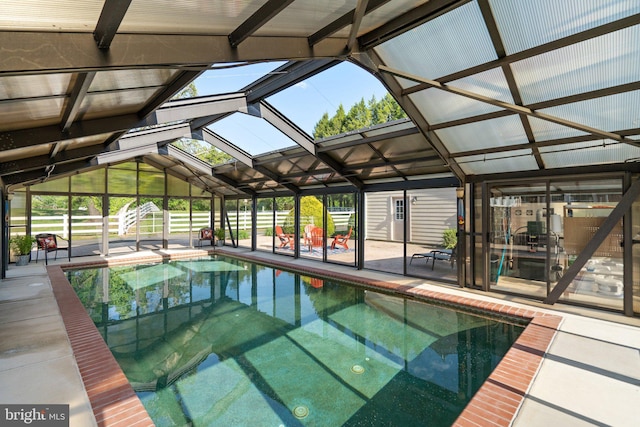 pool with glass enclosure and a patio area