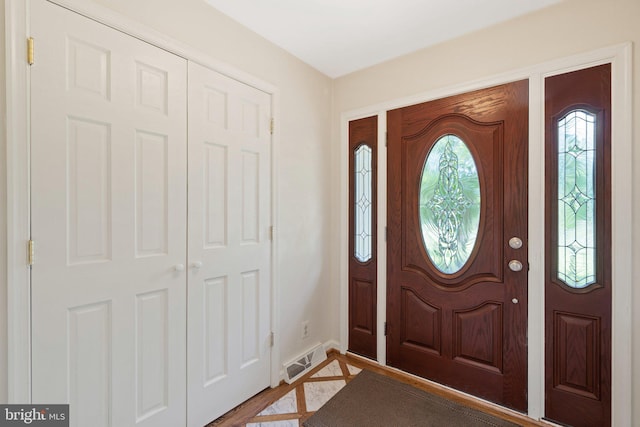 foyer entrance featuring light wood-type flooring and visible vents