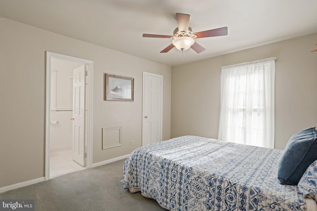 carpeted bedroom with connected bathroom, ceiling fan, and baseboards