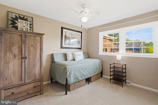 bedroom with light carpet, ceiling fan, and baseboards