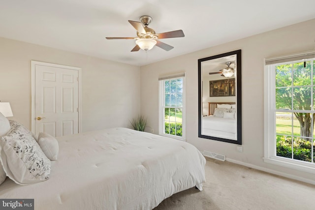 carpeted bedroom with baseboards, visible vents, and a ceiling fan