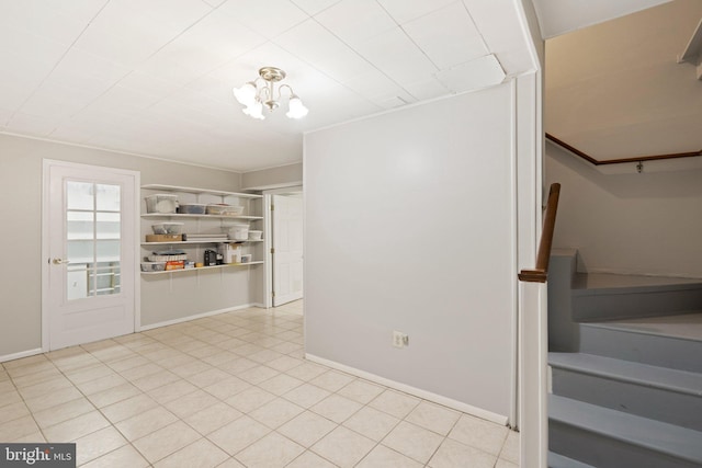 unfurnished dining area with light tile patterned floors, baseboards, and a notable chandelier