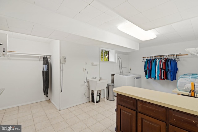 laundry area featuring laundry area, light tile patterned floors, a sink, and independent washer and dryer