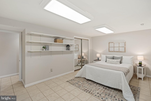 bedroom featuring light tile patterned floors, a closet, visible vents, and baseboards