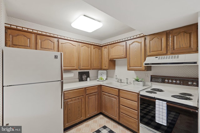 kitchen with light countertops, brown cabinetry, a sink, white appliances, and exhaust hood