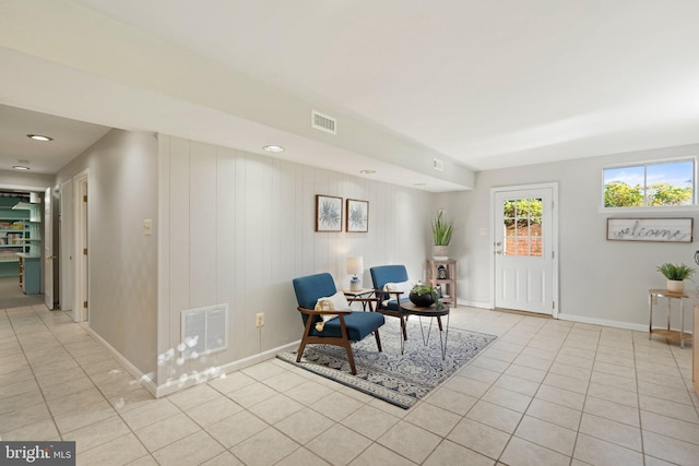 living area with baseboards, visible vents, and light tile patterned flooring