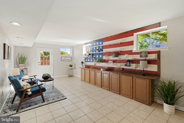 living area featuring light tile patterned flooring and baseboards