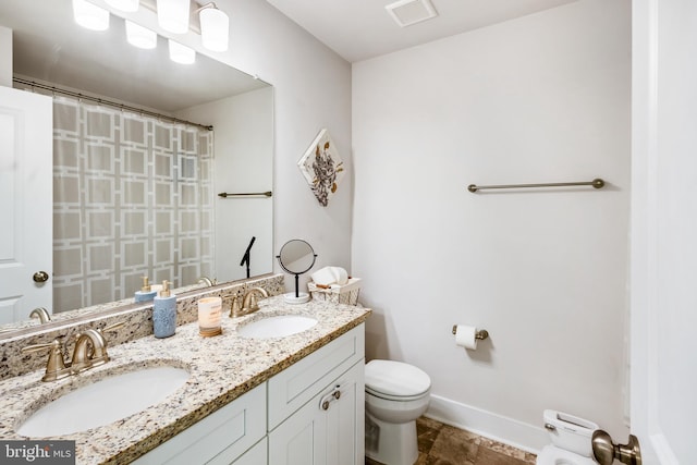 bathroom with toilet, a sink, visible vents, and baseboards