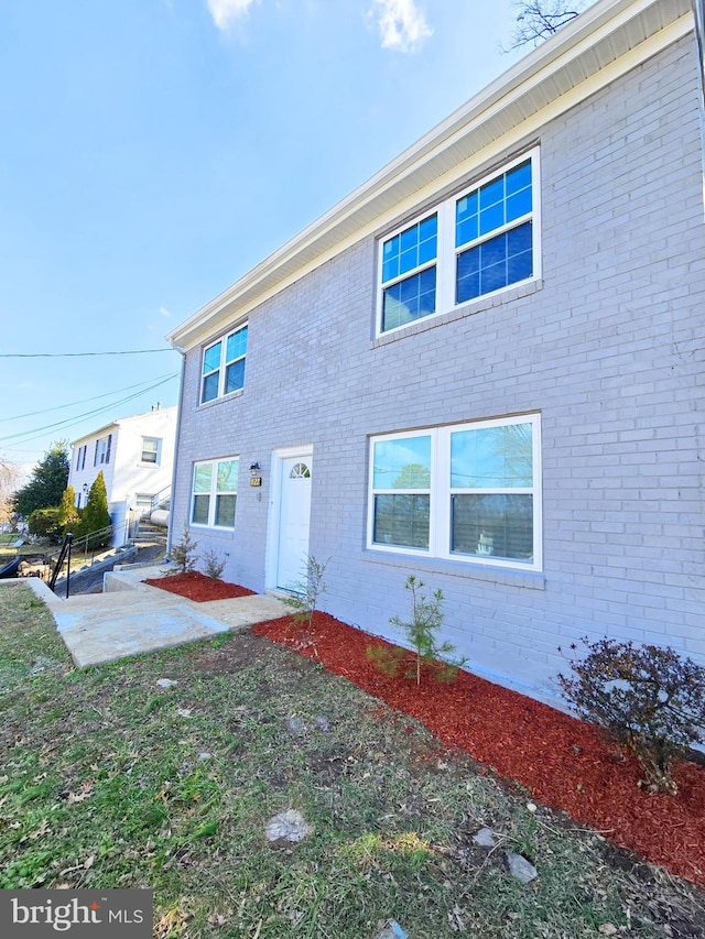 view of front of house with brick siding and a patio