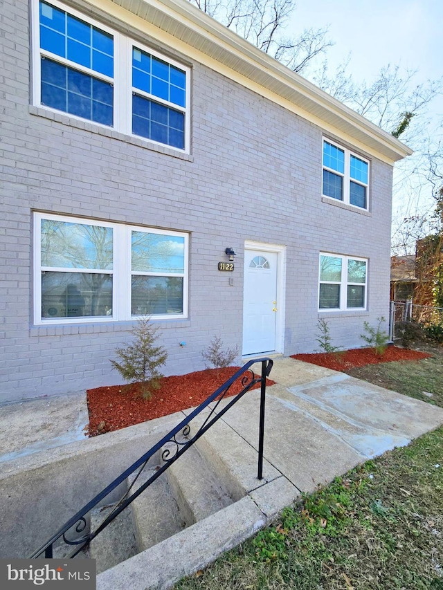 view of property featuring a patio and brick siding