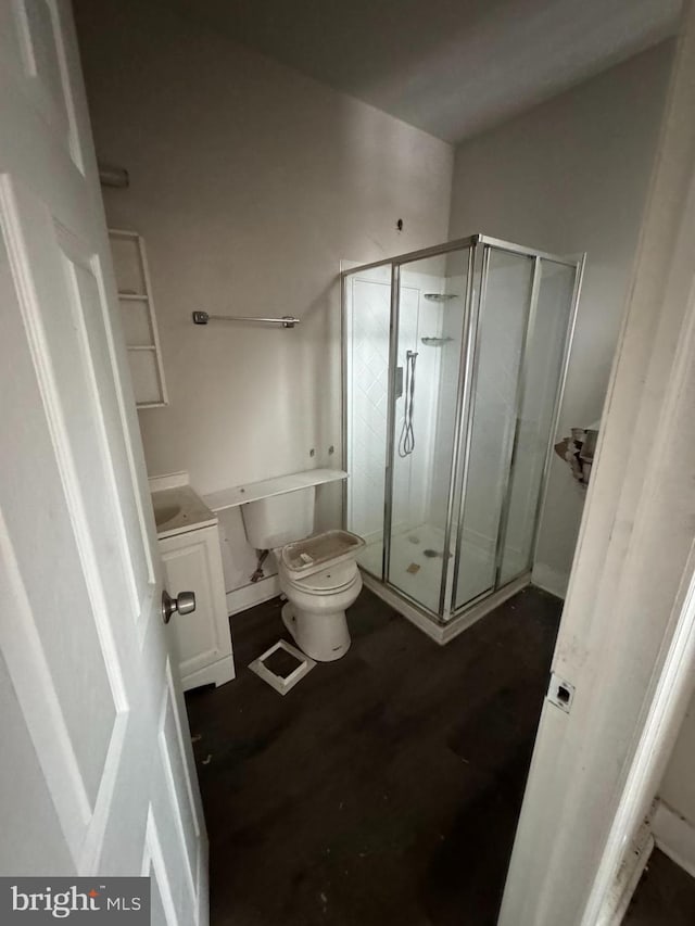 bathroom with vanity, toilet, and a shower with shower door