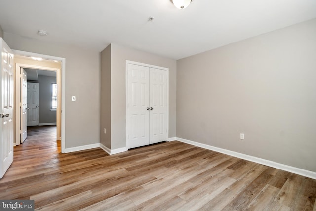 unfurnished bedroom with a closet and light wood-type flooring