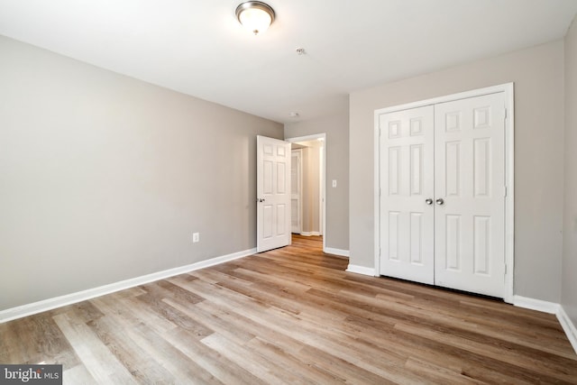 unfurnished bedroom featuring light hardwood / wood-style floors and a closet