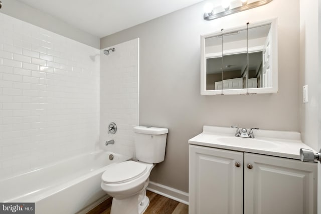 full bathroom featuring tiled shower / bath, hardwood / wood-style floors, vanity, and toilet