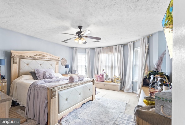 bedroom with light carpet, ceiling fan, a textured ceiling, and visible vents