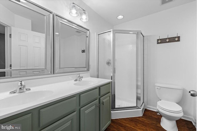 bathroom featuring vanity, wood-type flooring, a shower with shower door, and toilet