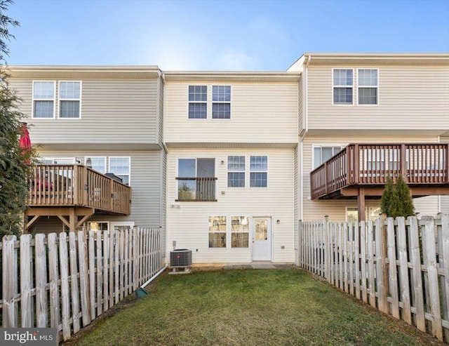 back of property with cooling unit, a yard, and a wooden deck