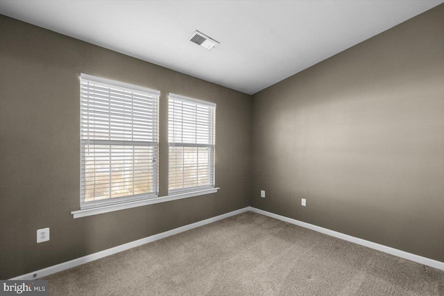 carpeted spare room featuring vaulted ceiling