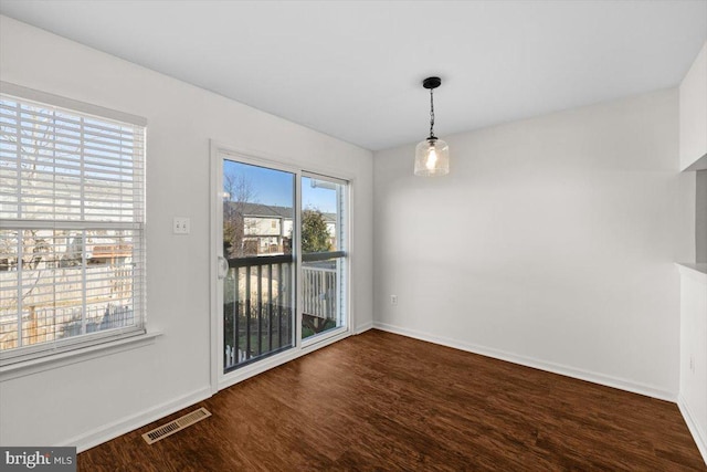 unfurnished dining area with dark wood-type flooring