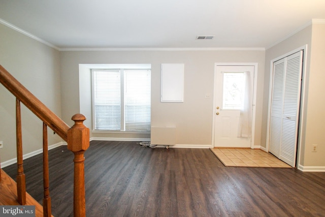 foyer entrance with crown molding and dark hardwood / wood-style floors