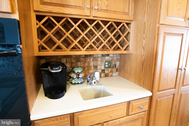 bar featuring a sink, a dry bar, and decorative backsplash