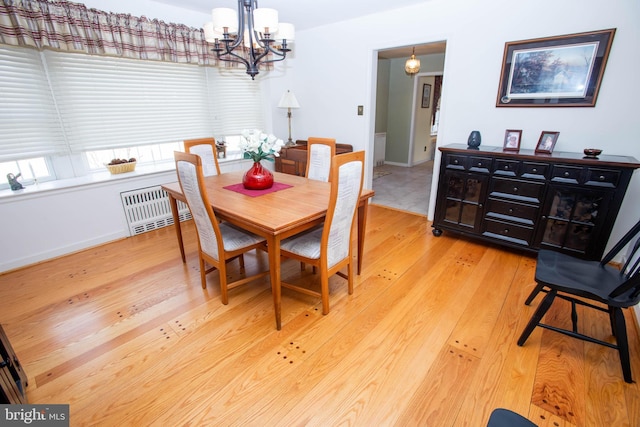 dining area with an inviting chandelier, light wood-style flooring, visible vents, and baseboards