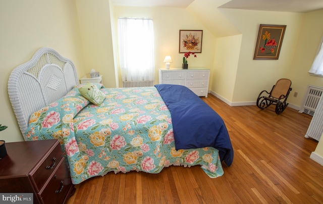 bedroom featuring radiator, baseboards, and light wood finished floors