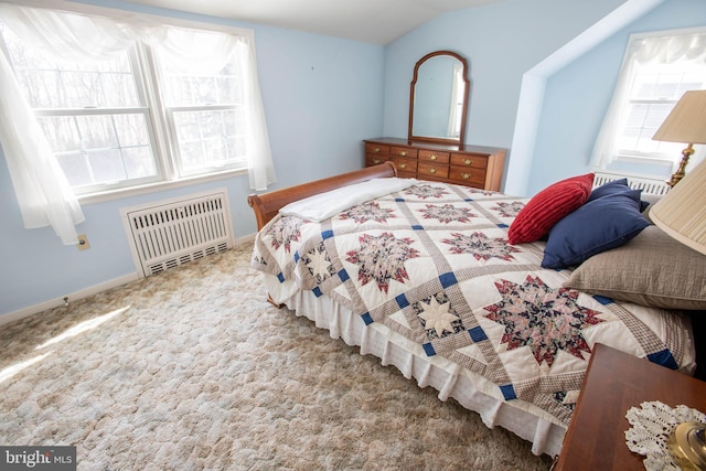 carpeted bedroom featuring radiator heating unit, baseboards, and vaulted ceiling