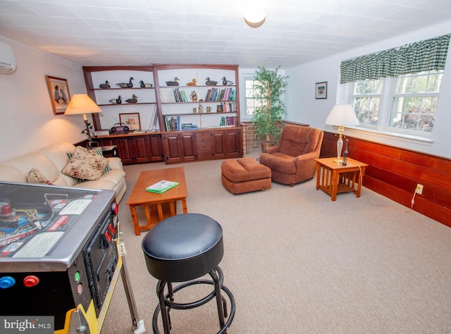 living room with a wall mounted AC, wainscoting, light colored carpet, and wooden walls