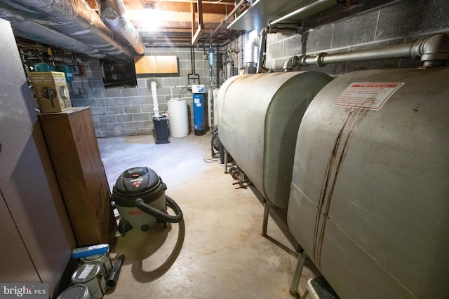 unfinished basement featuring concrete block wall and heating fuel