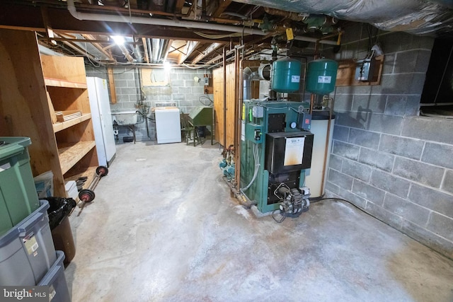 unfinished below grade area featuring water heater, a heating unit, and washer / clothes dryer