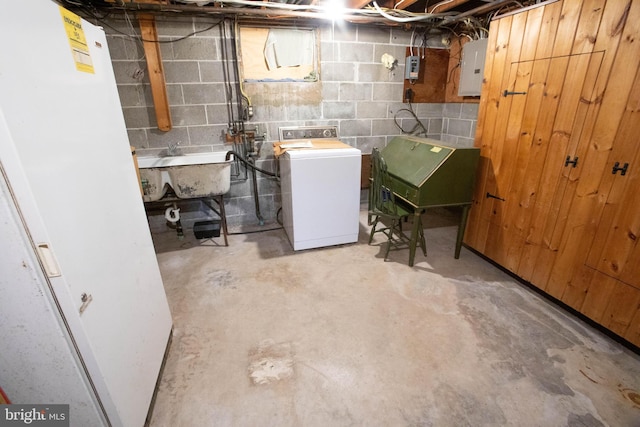 unfinished basement with a sink, washer / dryer, and electric panel