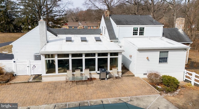 back of property featuring a sunroom, a chimney, fence, and roof with shingles