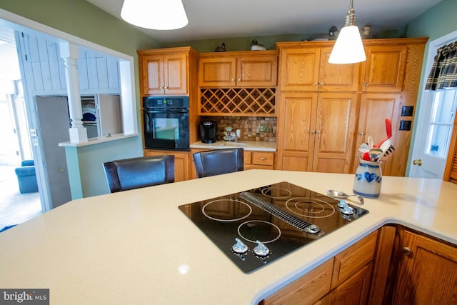 kitchen featuring light countertops, hanging light fixtures, and black appliances