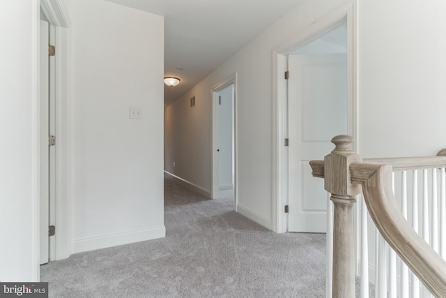 hall featuring light colored carpet