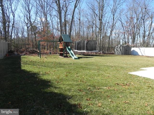 view of yard with a playground, a fenced backyard, an outdoor structure, a storage unit, and a trampoline