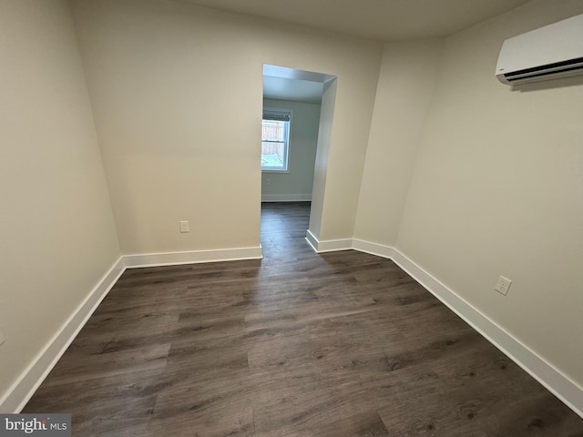 spare room featuring dark hardwood / wood-style floors and a wall mounted air conditioner