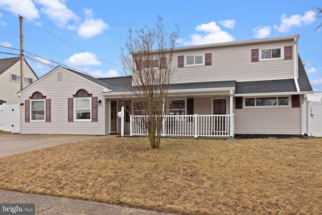 front facade featuring covered porch and a front yard